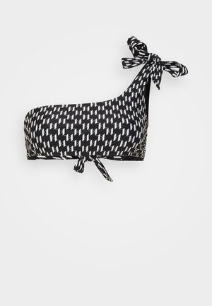 Top de bikini cu un umăr și detaliu cu fundiță, având un model geometric alb-negru, realizat dintr-un material neted și elastic.