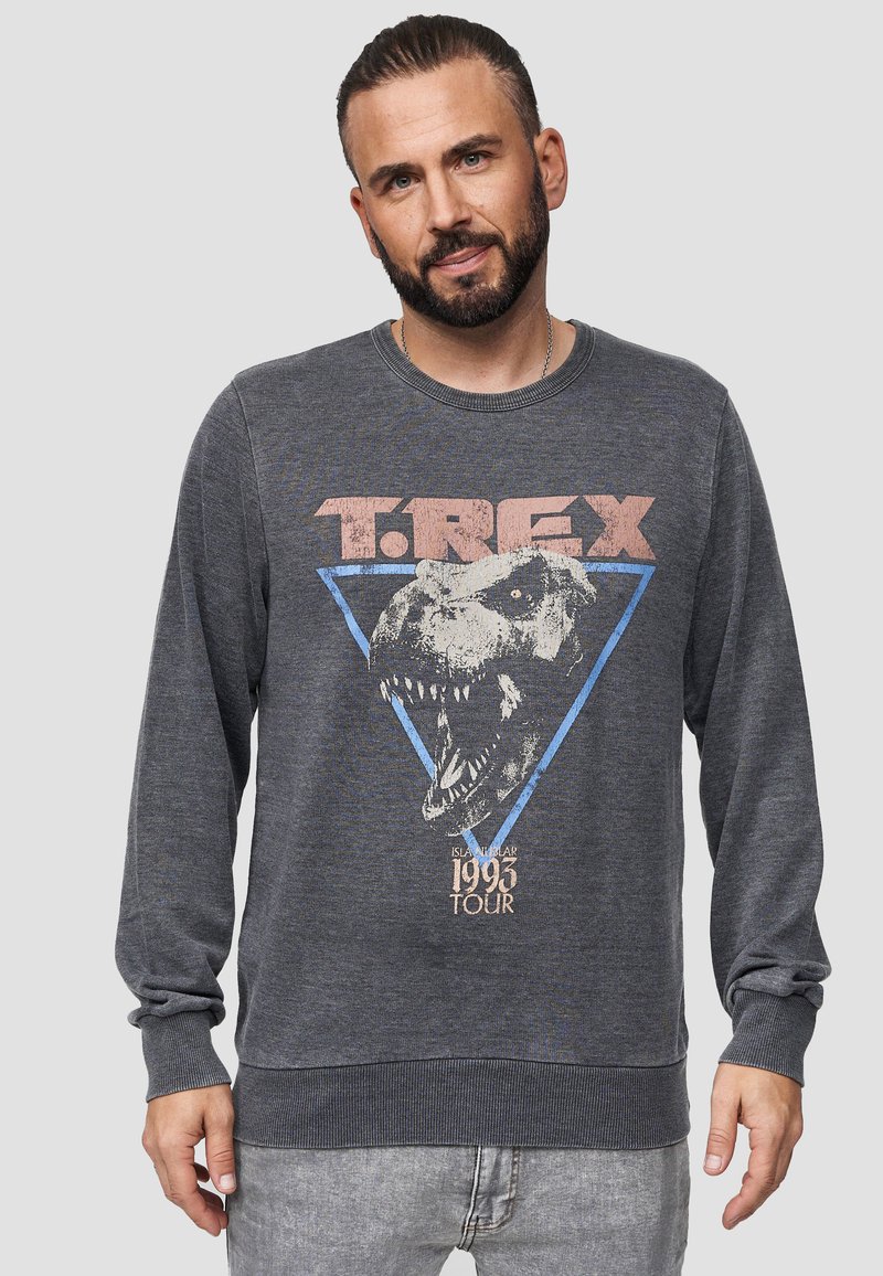 Grijze sweatshirt met lange mouwen met een T-Rex-afbeelding en tekst, geribbeld ronde hals en mouwen. Heeft een blauw driehoekontwerp en vintage details van de tour in 1993.