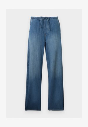Pantalon en denim bleu à jambes larges avec taille élastique et cordon, présentant un effet délavé sur le devant des jambes.