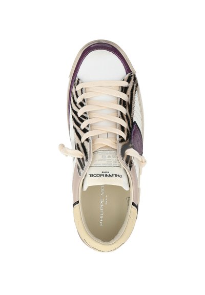 Witte en beige sneaker met zebra print aan de zijkanten, crèmekleurige veters, paarse afwerking op de neus en "Philippe Model Paris" branding aan de binnenkant.