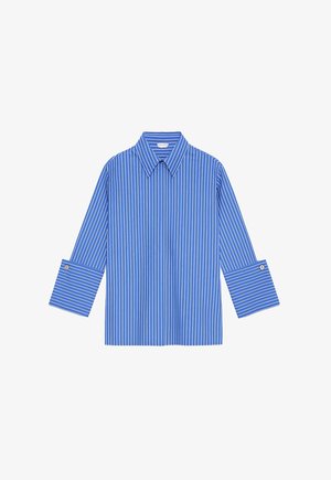 Chemise bleu clair à boutons avec rayures blanches verticales, larges poignets et col pointu, présentée à plat sur un fond blanc.