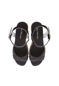 Sandalias de cuero negro con suela de corcho, tiras en el tobillo y diseño entrelazado. Textura suave y acentos dorados en la plantilla.