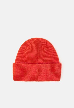 Bonnet en maille côtelée orange vif avec un revers plié, posé à plat sur un fond clair.