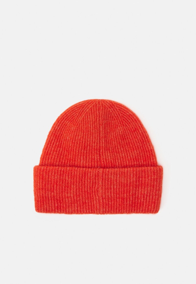 Bonnet en maille côtelée orange vif avec un revers plié, posé à plat sur un fond clair.