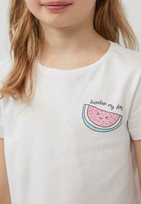 Witte katoenen t-shirt met korte mouwen, voorzien van een watermeloen graphic zakprint en de tekst "sweeten my day" in het zwart.