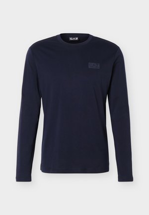 T-shirt bleu marine à manches longues avec col rond, arborant un logo EA7 Emporio Armani discret sur le côté gauche de la poitrine et à l'intérieur du col.