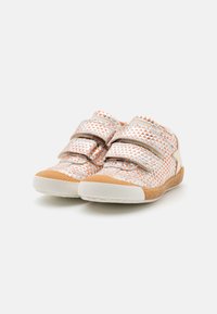 Buty na rzepy z geometricznym wzorem w pomarańczowym i białym kolorze, z gumową podeszwą i teksturowanym materiałem górnym. Akcenty w jasnobeżowym kolorze.