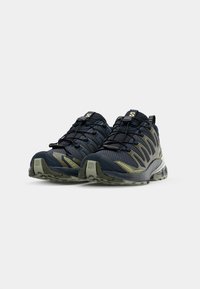 Blue and olive green athletic shoes with mesh upper, textured sole, laces, and prominent logo on the tongue and side.