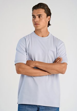 Lys blå kortærmet t-shirt med rund halsudskæring og en brystlomme. Fremstillet af glat bomuldsstof med en lige pasform og sideslidser.