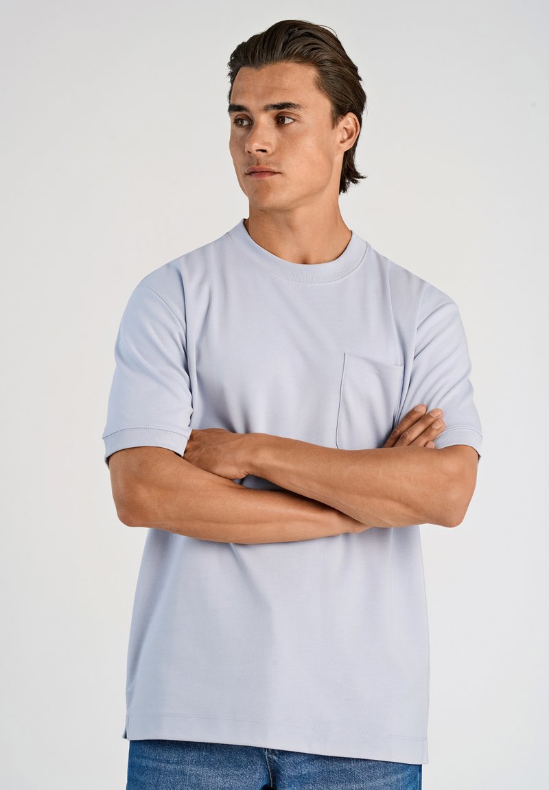 T-shirt azzurro chiaro con maniche corte, colletto rotondo e tasca sul petto. Realizzato in morbido tessuto di cotone, ha una vestibilità dritta e aperture laterali.
