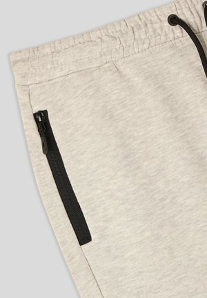 Pantaloni grigi di felpa con una texture morbida, vita elasticizzata e tasche con zip nere sui lati per riporre gli oggetti.