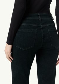 Zwarte jeans met een hoge taille, voorzien van twee achterzakken en een gladde textuur. De stof lijkt duurzaam en figuurvormend.