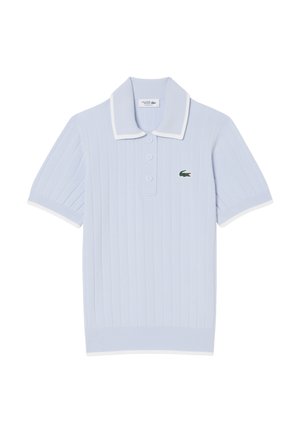 Hellblaues, geripptes Poloshirt mit weißem Kragen und Bündchen, versehen mit einem grünen, gestickten Krokodil-Logo auf der linken Brustseite. Drei-Knopf-Leiste.