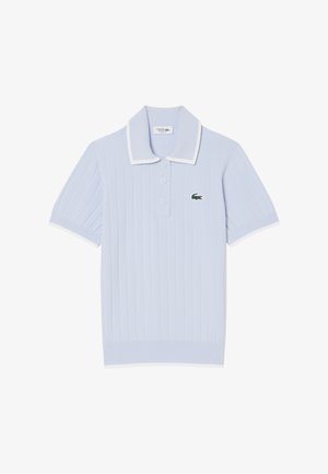 Hellblaues, geripptes Poloshirt mit weißem Kragen und Bündchen, versehen mit einem grünen, gestickten Krokodil-Logo auf der linken Brustseite. Drei-Knopf-Leiste.