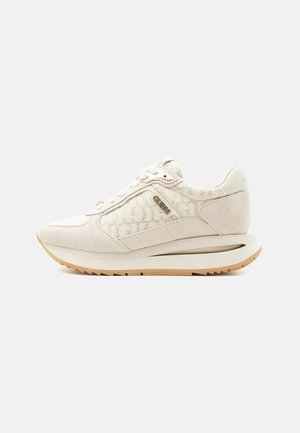 Jasnobeżowy sneaker z zamszu i wzorzystej tkaniny, wiązany na sznurowadła, z metalowym logo marki po boku i gumową podeszwą.