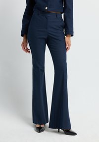 - Spodnie materiałowe