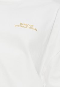 Άσπρο βαμβακερό μπλουζάκι με το "Barbour International" κεντημένο σε χρυσό. Απλός σχεδιασμός με κλασικό λαιμόκομμα και μαλακή υφή.