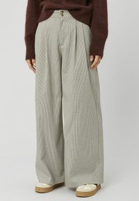 Pantalon à jambes larges à motif à carreaux, avec une taille haute et des plis. Tissu léger avec une texture subtile ; détail des boutons à la taille.