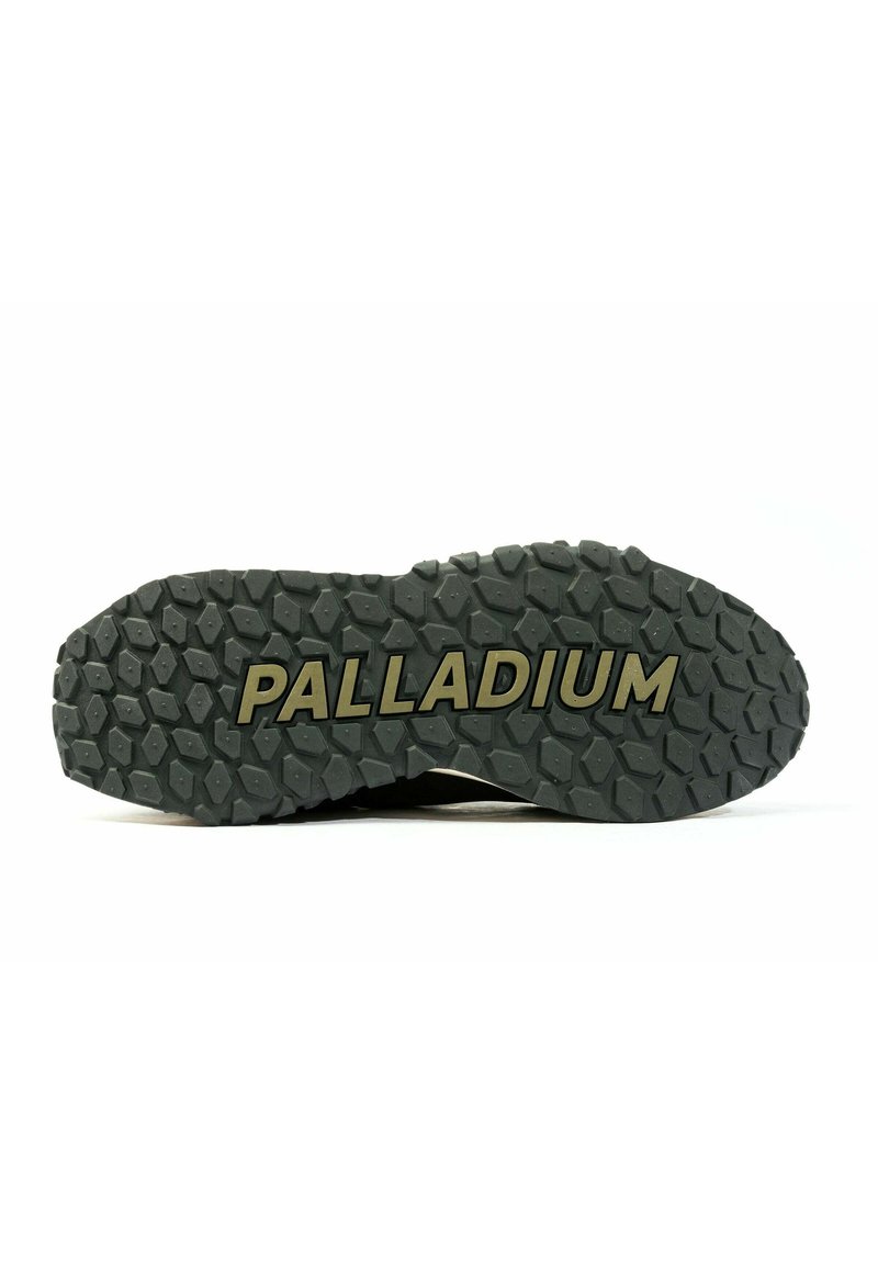 Podeszwa obuwia Palladium, charakteryzująca się solidnym czarnym gumowym wzorem z teksturowanym deseniem oraz wypukłym logo "PALLADIUM" w kolorze złotym.