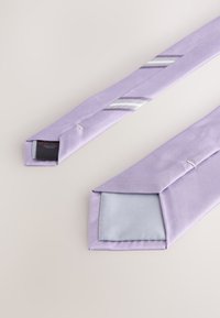 Lilac tie with a textured surface and diagonal stripes. The ends are square, featuring a contrasting inner lining.
