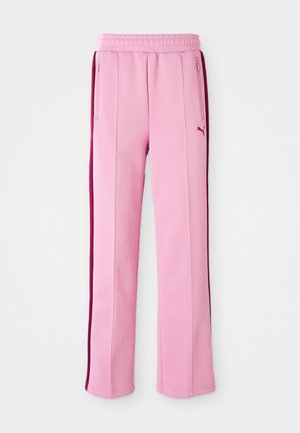 Pink athletic pants made of smooth fabric, featuring side zip pockets and burgundy accents along the outer seams. Elastic waistband at the top.