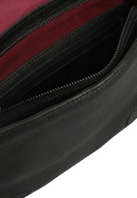 Borsa nera in pelle con una finitura testurizzata, dotata di più scomparti con cerniera e un interno cremisi.