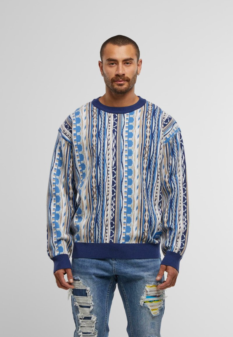 Blauwe gebreide trui met een ronde hals, voorzien van verticale strepen in verschillende tinten blauw en crème, met geribde marineblauwe manchetten en zoom.
