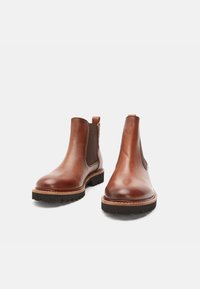 Ruskeat nahkaiset Chelsea-nilkkurit, joissa on joustavat sivupaneelit ja vetotappi, pyöreä kärki ja kestävä kumipohja.