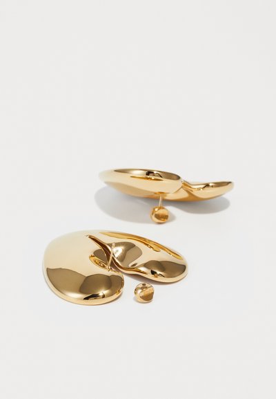 Orecchini in metallo color oro con una forma fluida e organica. Presentano un perno centrale e un piccolo accento a sfera, il finish lucido ne esalta la qualità riflettente.