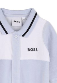 Jasnoniebieska koszulka polo z białym poziomym paskiem, czarnym kołnierzykiem w paski, zapięciem na guziki oraz czarnym logo BOSS.