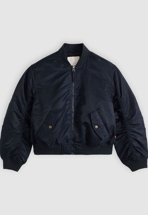 Μπουφάν μπόμερ σε ναυτικό μπλε με φερμουάρ μπροστά, δύο λοξές τσέπες με καπάκι και κουμπιά, ριμπ γιακά, μανσέτες και μέση, απλωμένο επίπεδα.