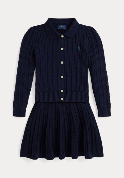 Vestido de malha azul marinho com gola canelada, fecho debotões na frente e saia plissada. Apresenta um design de tricot com cabos e um pequeno logótipo no peito.