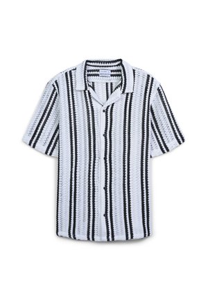 Camicia bianca a maniche corte con bottoni, caratterizzata da un motivo a righe verticali nere e un tessuto a trama intrecciata, posata su uno sfondo bianco.