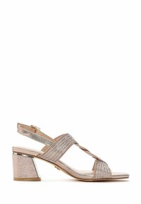 Sandale ouverte en matériau métallique rose clair avec des brides pailletées, design croisé et un talon carré avec un accent argenté.