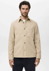 Beige bomulds skjortejakke med lange ærmer, frontlommer, knaplukning og en struktureret krave. Glat texture og afslappet pasform.