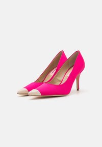Hot pink high-heeled pumps with a beige cap toe, smooth fabric surface, and a slim stiletto heel.