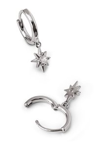 Boucles d'oreilles créoles argentées avec un pendentif en forme d'étoile suspendu, avec une pierre précieuse claire au centre et une finition métallique polie.