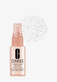 Clinique Moisture Surge Gesichtsspray in einer transparenten, matten rosa Flasche mit Sprühkopf; Wassertropfen im Hintergrund.