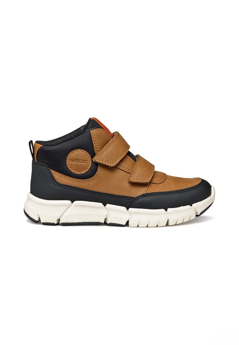 Zapato de caña alta en marrón y negro con dobles correas de Velcro, suela de goma, parte superior de cuero texturizado y detalle de marca circular.