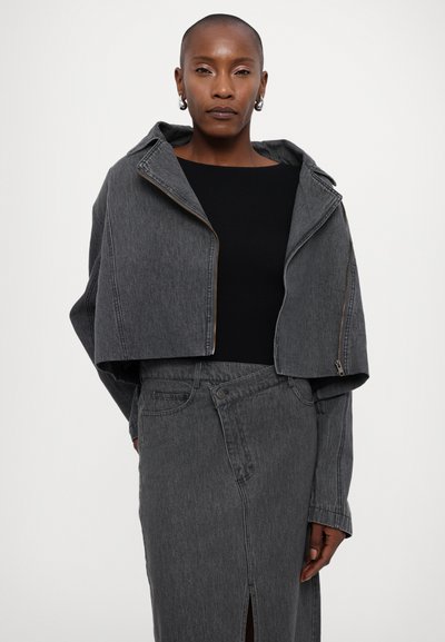 Kuttet grå denimjakke med hette og frontglidelås, sammen med en svart topp og grå denimskjørt med frontsplitt.