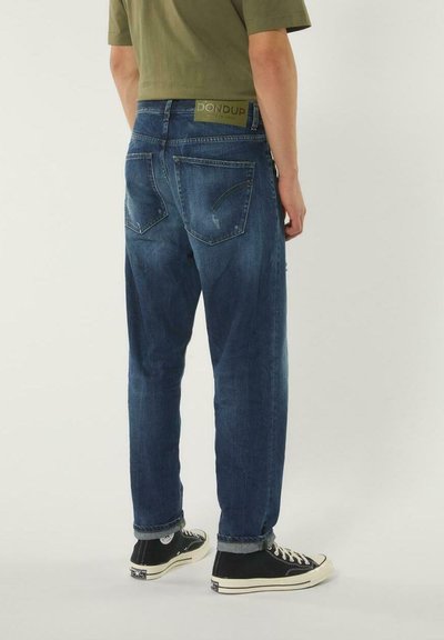 Jeans in denim blu scuro con una finitura leggermente rovinata, taglio dritto e orli arrotolati. Presentano una vita con logo e due tasche posteriori.