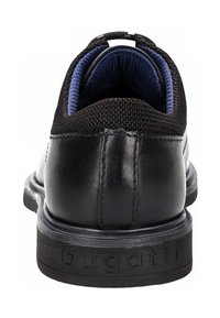Baskets noires en cuir et mesh avec intérieur matelassé bleu marine, semelle épaisse embossée du logo « bugatti », vues de dos.