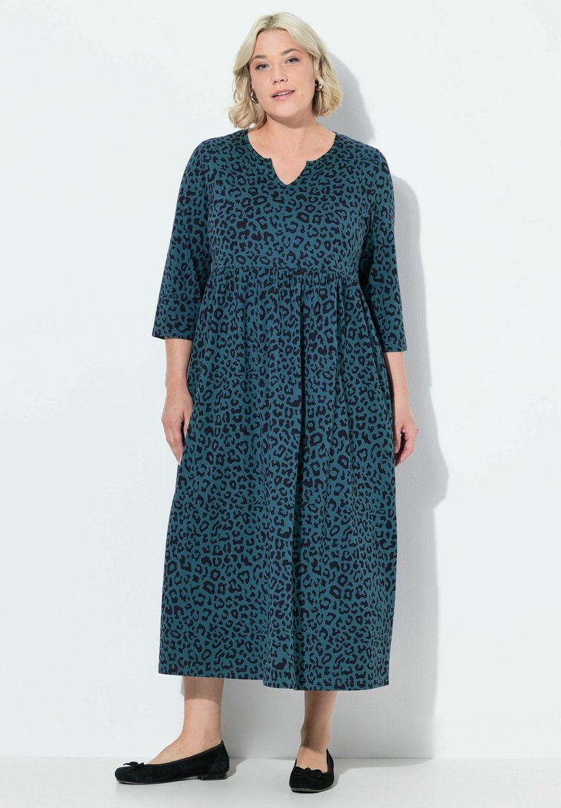 Robe longue teal avec un motif léopard, dotée d'un décolleté en V et de manches ¾. Le tissu semble doux avec un design ample et fluide.