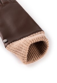 Brown leather glove with knitted beige cuff, featuring a ribbed texture and a small metal accent near the wrist.