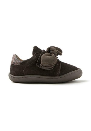 Zapato de ante marrón con punta redondeada, gran lazo en la parte delantera y un acento brillante en la parte trasera. Suela de goma flexible.