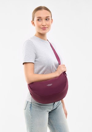 Borsa a spalla bordeaux realizzata in materiale morbido; forma arrotondata con una tracolla. Logo visibile sul davanti; design minimalista.