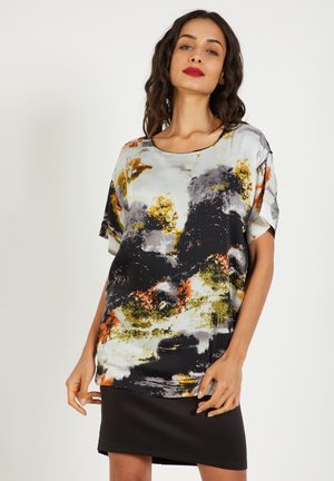 Blusa de manga corta y corte holgado en tejido ligero. Presenta un patrón abstracto multicolor con tonos en negro, blanco, naranja y verde.