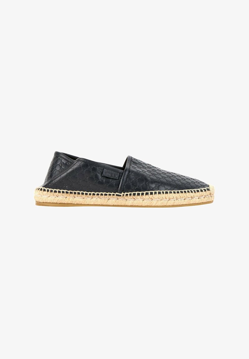 Chaussure espadrille en cuir noir avec semelle en jute tissée cousue, motif embossé sur la tige et design slip-on vue de profil.