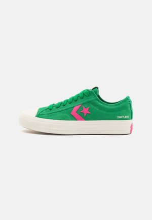 Grøn low-top ruskindssneaker med pink stjernelogo, hvid gummisål, snørebånd og teksten "Star Player" på hæl-siden.