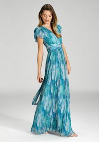 Robe maxi bleu et verte avec un motif aquarelle, à manches courtes volantées, décolleté en V et taille cintrée, fabriquée en tissu léger.